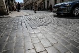 Ulica prowadząca do Rynku Głównego w Krakowie pełna dziur i nierówności