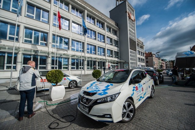 Koszalin był punktem kontrolnym na trasie rajdu samochodów elektrycznych Tallsinki – Monte Carlo Electric Marathon 2018. Przed ratuszem można było podziwiać m.in. teslę model S P85D, czy też... warszawę z napędem elektrycznym.- Uczestnicy rajdu jadą ze stolic Finlandii i Estonii do Monte Carlo, by pokazać, że całą Europę można przejechać samochodem elektrycznym – podkreślił Piotr Jedliński, prezydent Koszalina, który przed ratuszem powitał załogi i wręczył medale kierowcom oraz pilotom, którzy najszybciej pokonali odcinki kontrolne pomiędzy Kaliningradem i Gdańskiem oraz drugi – z Gdańska do Koszalina, który zakończyli w nocy z piątku na sobotę. - Wydarzenie to wpisało się w obchody Europejskiego Tygodnia Zrównoważonego Transportu – dodał włodarz miasta.- Rajd odbywa się w dwóch kategoriach – pierwsza to samochody marki nissan leaf, a startują w nich studenci uniwersytetów między innymi z Japonii i Monako. W drugiej startują wszystkie samochody z napędem elektrycznym – wyjaśnił Jüri Tamm, konsul honorowy Monako w Estonii i jednocześnie dyrektor generalny rajdu. Na czym polega rywalizacja? – Wyznaczone odcinki pokonuję jako pierwszy samochodem z silnikiem spalinowym. Kierowcy aut z napędem elektrycznym nie znają mojego czasu przejazdu. Dopiero na mecie porównujemy ich czas z moim, który jest czasem zerowym – wyjaśnił komandor rajdu. Co ciekawe, Jüri Tamm jest nie tylko jednym z pomysłodawców tej rywalizacji. Sportem żyje od lat – to dwukrotny medalista olimpijski w rzucie młotem.- Ideą naszego maratonu jest promowanie oszczędzanie energii, zielonych technologii, innowacyjności i właśnie sportu – powiedział nam. – Rajdy samochodowe kojarzą się z walką gladiatorów, a kierowcy aut z napędem elektrycznym są raczej na ich tle, jak szachiści – żartował. – Ważne dla nas jest jednak to, by edukować społeczeństwo. Pokazać, jakdziałają samochody na prąd i jak się je ładuje.A chętnych by auta zobaczyć, nie brakowało. Szczególnym zainteresowaniem cieszyły się dwie tesle model S P85D oraz wyprodukowana w Moskwie warszawa, przerobiona na „elektryka”. – Podróżowanie samochodem elektrycznym będzie wygodne wtedy, gdy właśnie mniejsze miasta będą dysponować infrastrukturą niezbędna do ładowania baterii. Dziś między Szczecinem a Gdańskiem jest z tym kłopot, dlatego szczególnie cieszę się, że w Koszalinie dzięki tej inicjatywie o elektrycznych autach jest głośno – usłyszeliśmy od jednego z gości wydarzenia.Rajd do Monte Carlo wystartował 17 września. Odbywa się zgodnie z kodeksem ruchu drogowego po drogach publicznych. Pomysł na jego organizację należy do księcia Alberta II z Monako, drugim pomysłodawcą jest Jüri Tamm. Pierwszy rajd odbył się w 2011 roku, po raz pierwszy - uczestnicy przejechali wtedy przez przez Estonię, Finlandię, Szwecję, Danię, Niemcy, Szwajcarię, Włochy, Francję do Monako. Rok później po raz pierwszy trasa wyścigu objęła Polskę. W tym roku uczestnicy jadą z Finlandii i Estonii, a na trasie rajdu jest Łotwa, Litwa, Rosja, Polska, Niemcy, Luksemburg, Francja – aż do Monako. Jadą przez Europę z północy na południe, od Morza Bałtyckiego do Morza Śródziemnego. Finał imprezy 29 września.