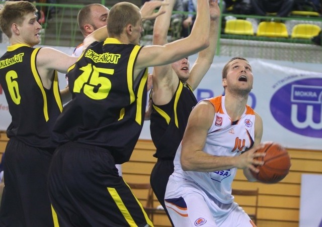 Michał Przybylski (z piłką) walczy z koszykarzami Sokoła Łańcut.