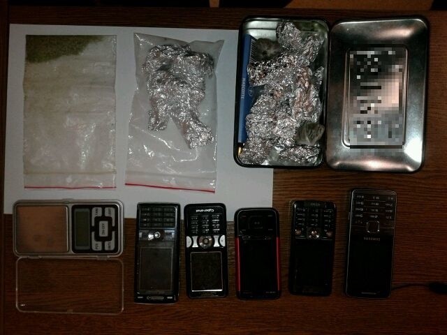 Narkotyki, elektroniczna waga i telefony komórkowe zabezpieczone przez policjantów podczas przeszukań.