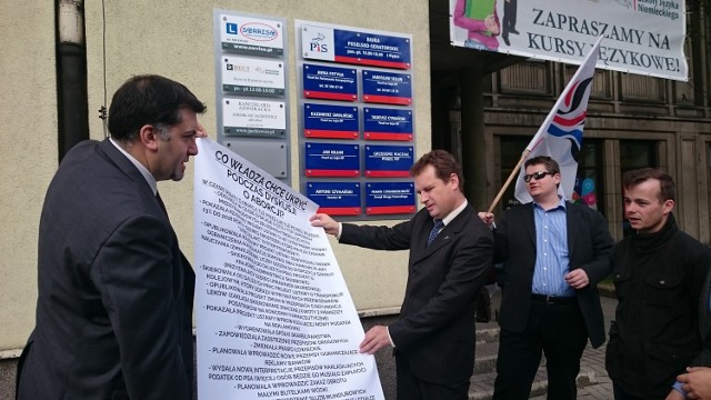Członkowie KNP zaprezentowali plakat, na którym w punktach wyszczególnili zmiany wprowadzane przez PiS