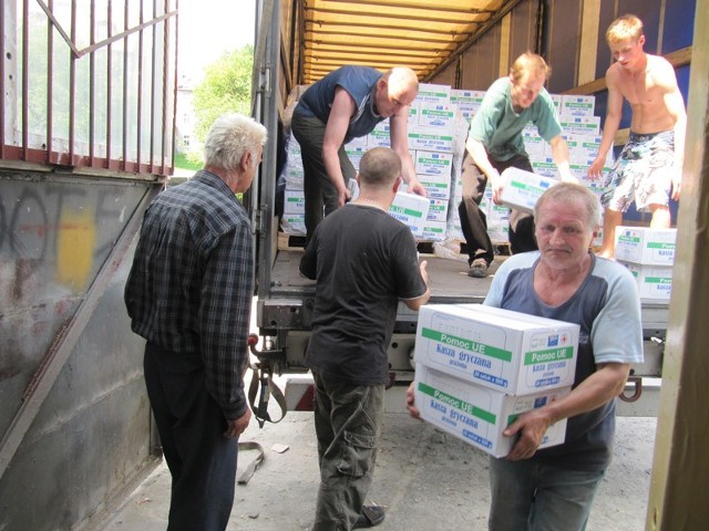 Żywność potężnymi ciężarówkami zjeżdża do koszalińskiego oddziału PCK. Przy ich rozładunku pracuje kilkanaście osób.