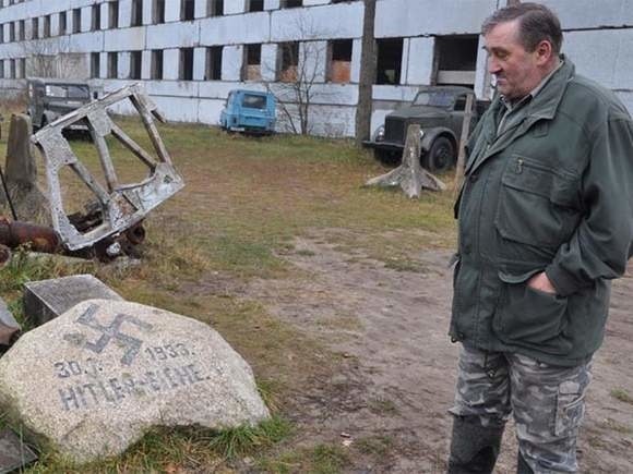Andrzej Michalak ze znalezionym głazem upamiętniającym dojście Hitlera do władzy. Kamień leżał przy dębie Hitlera