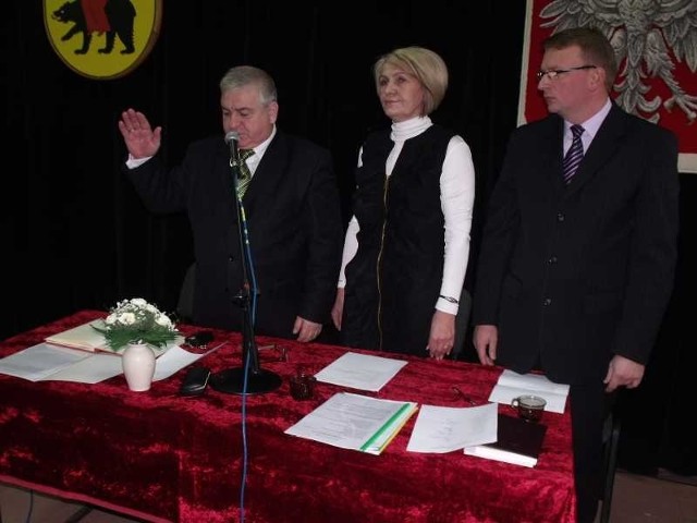 Marcin Majcher, burmistrz Ożarowa, składa ślubowanie. Obok burmistrza Krystyna Wieczorek, przewodnicząca Rady Miejskiej w Ożarowie i wiceprzewodniczący Grzegorz Dzikowski.