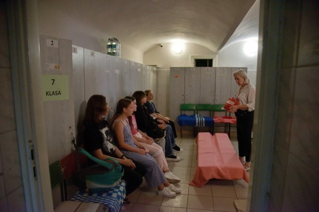 Uczniowie i nauczyciele ćwiczą ukrycie się w szkolnym schronie na wypadek alarmu bombowego w jednej z polskich szkół we Lwowie.
