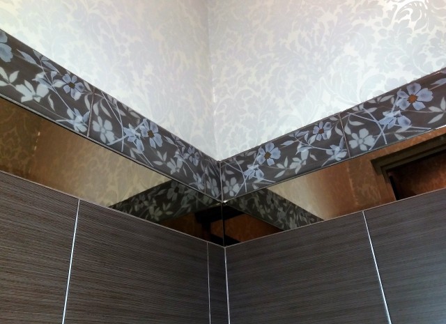 Odpowiednio dobrany wzór tapety w łazience dobrze wygląda w połączeniu z płytkami ściennymi.