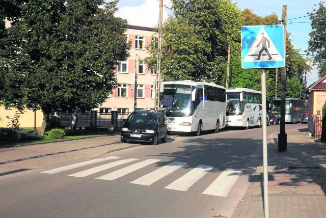 Pojazdy stojące wzdłuż drogi  utrudniają jazdę po wąskiej ulicy Poniatowskiego.