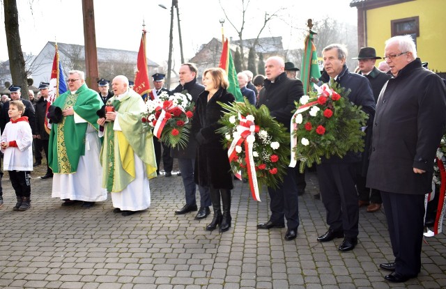 Kwiaty pod tablicą powstańców składają: ksiądz Krzysztof Rusiecki, Ksiądz Stanisław Wiktor, poseł Marek Kwitek, posłanka Anna Krupka, wicewojewoda świętokrzyski Rafał Nowak, staszowski starosta Jan Żółciak i wiceprzewodniczący Rady Powiatu staszowskiego Stanisław Batóg.