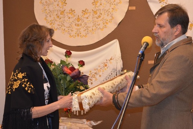Barbara Jankowska, przewodnicząca  zespołu haftu artystycznego  odbierała  prezent od dyrektora TOK
