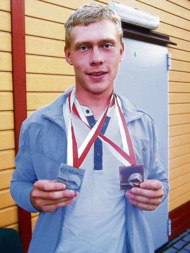 Patryk Pietryszyn z dumą pokazuje medale zdobyte podczas mistrzostw Polski