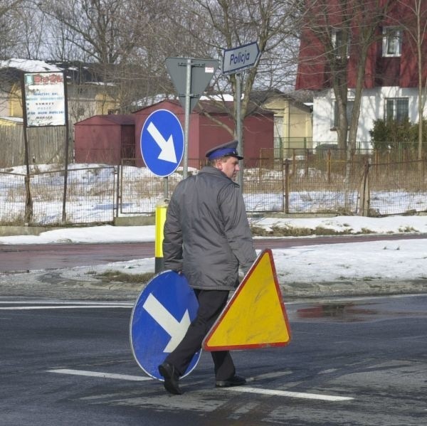 Podczas niedawnego wypadku na skrzyżowaniu w Łoniowie samochód uszkodził znaki drogowe. Policjant niesie je do pobliskiego komisariatu.