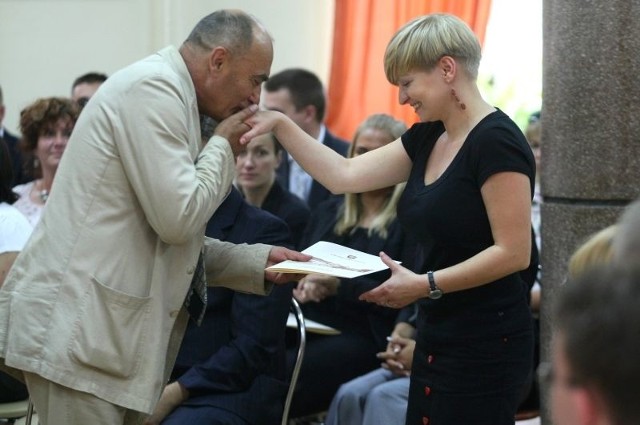 Renata Janisławska odbiera dokument z rąk wiceprezydenta Kielc, Andrzeja Syguta.