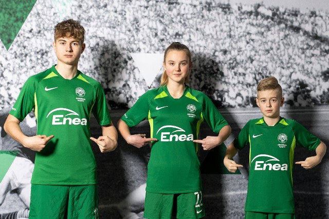 Młodzież piłkarska Warty Poznań dumnie prezentuje koszulki z logotypem Enei