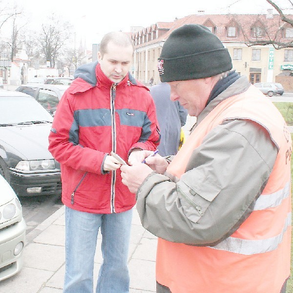 Bronisław Chojnacki sprzedaje bilet Grzegorzowi Kubiakowi.