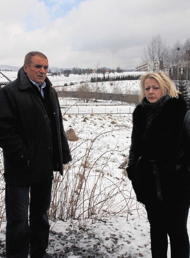 Małgorzata Fredrik i Lesław Mikołajski na tle działek (tam, gdzie rząd krzewów w oddali) na których mają powstać nowe groby.