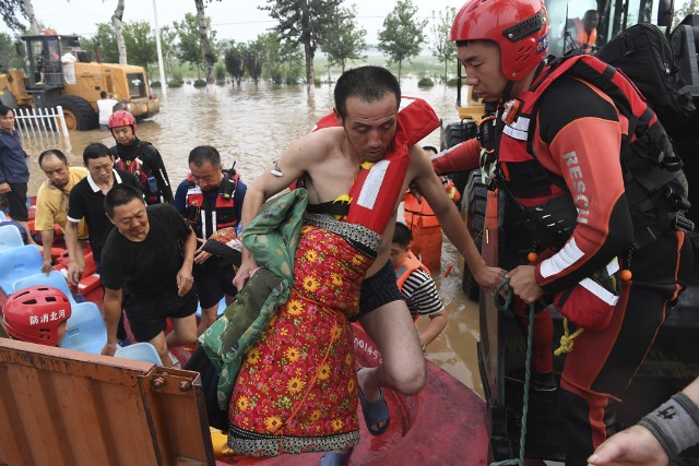 Ratownicy pomagają uwięzionym mieszkańcom w Zhuozhou w prowincji Hebei na północy Chin.