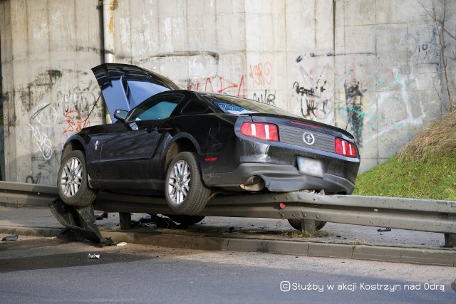 W sobotę 8 stycznia policja i straż pożarna zostały wezwane do nietypowej kolizji przy ul. Gorzowskiej w Kostrzynie nad Odrą. Kierowca mustanga nie dostosował prędkości do warunków na drodze i wpadł na bariery energochłonne. Amerykańskie auto na nich zawisło. - To musiało się tak skończyć. Ten kierowca w piątek w nocy szalał po całym mieście. Kilka razy widzieliśmy, jak z dużą prędkością przejeżdżał ulicą Wyszyńskiego - mówi nam jeden z mieszkańców miasta.W kolizji na szczęście nikt nie ucierpiał. Doszło do niej pod wiaduktem kolejowym, na łuku drogi przy ul. Gorzowskiej w Kostrzynie nad Odrą. Samochód wypadł z drogi i z dużą siłą wpadł na bariery energochłonne. Mostang na nich zawisł. Konieczna była pomoc strażaków. Na miejsce wezwano też pomoc drogową. Przyjechała również policja, która kierowała ruchem na czas akcji usuwania samochodu z barier. Zdjęcia z akcji publikujemy dzięki uprzejmości profilu facebookowego Służby w akcji Kostrzyn nad OdrąDo kolizji doszło na łuku drogi przy ul. GorzowskiejZobacz wideo: KRYMINALNY CZWARTEK - 27-latek kradzionym autem uciekał policji. Staranował radiowóz i próbował przejechać funkcjonariuszy! 