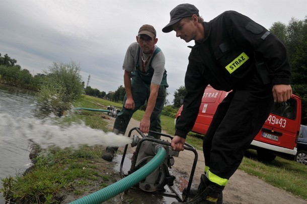 Druh Krzysztof Mikołajczak z OSP w Mozowie i Artur Kiljan z zakładu komunalnego uruchamiają pompę do napowietrzania wody w stawie