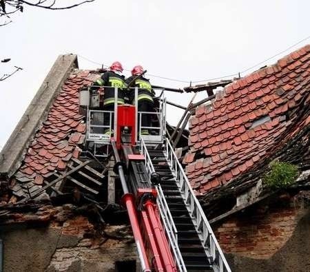 Strażacy z podnośnika usunęli zwisające krokwie dachu.