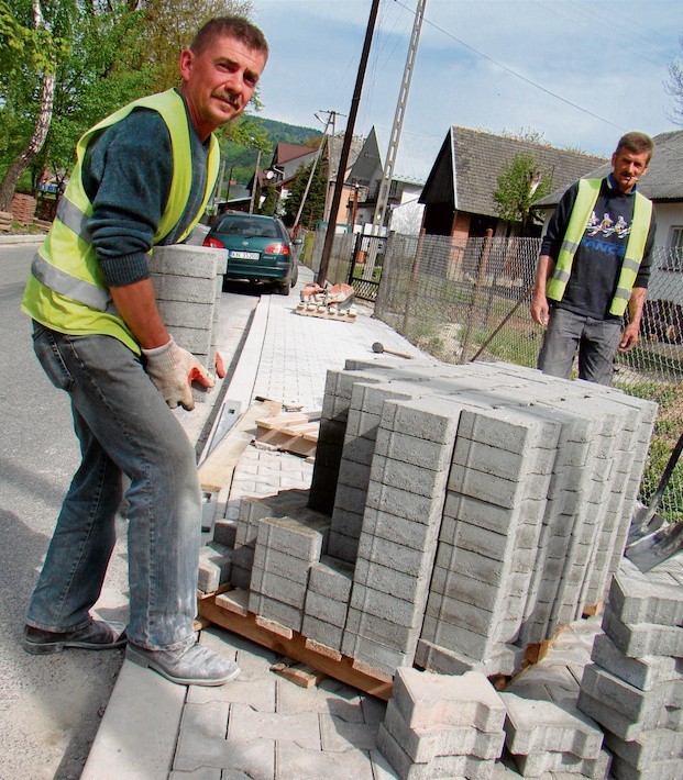 Robotnicy układają chodniki z kostki betonowej wzdłuż...