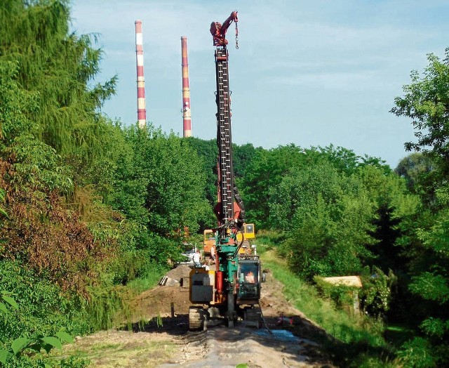 Ciężki sprzęt wykonuje betonową przesłonę na brzegu Białuchy