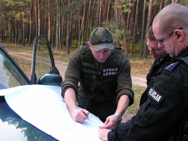 Na zdjęciu komendant straż leśnej Adam Gotowalski omawiana z policjantami plan akcji