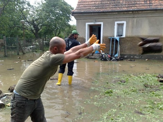 Krzysztof Dziadkiewicz i Rafał Mencel usuwają zalane drewno ze swojego podwórka