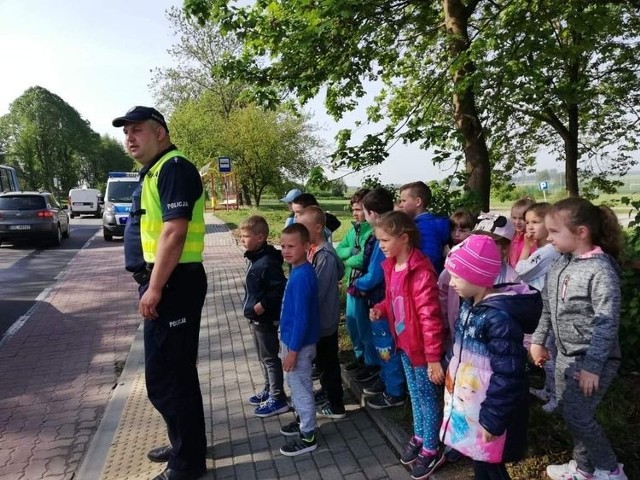 Asp. Robert Kornacki podczas służby z grupą uczniów, która czeka na instrukcje, kiedy można przejść przez jezdnię.