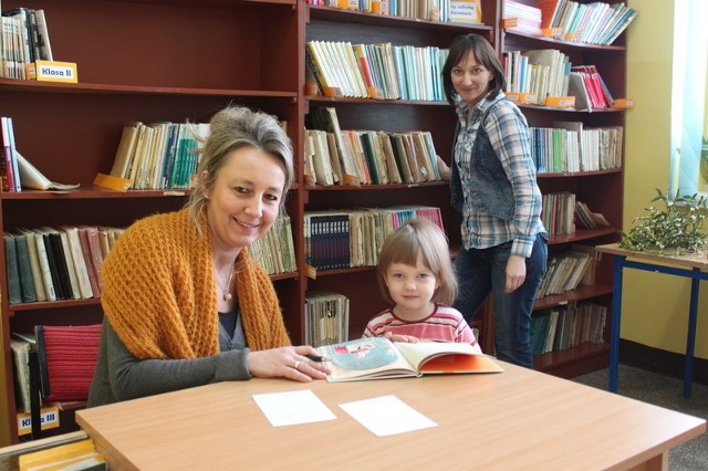Na zdjęciu bibliotekarka Kamila Drużyńska i pierwsi chętni do wypożyczania książek - Hanna Leśnikowska z córką Rozalką.