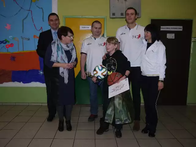 Jakub Chalecki w otoczeniu przedstawicieli Fundacji Marcina Gortata MG13, dyrektorki szkoły Mirosławy Latarowskiej i wuefistki Marioli Sowińskiej oraz wójta Grzegorza Doszela.