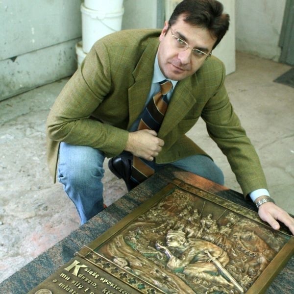 Kielecki rzeźbiarz Arkadiusz Latos prezentuje tablice z komiksem o legendzie powstania Kielc.