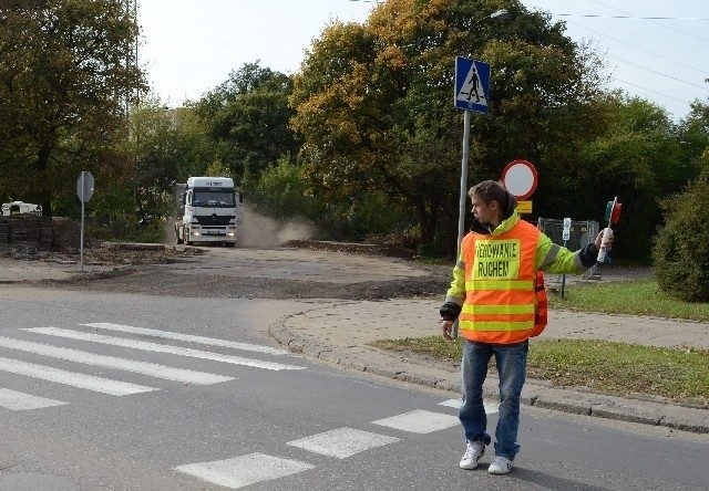 Specjalnie oznakowani pracownicy kierują ruchem ciężarówek.