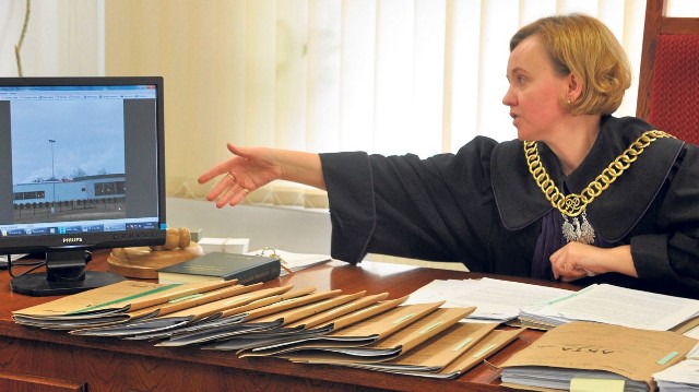 Sędzia Anna Lewita-Horyd ogląda zdjęcia kominów Kronospanu