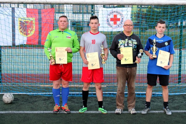 Na orliku przy ZSO w Tucholi odbył się turniej piłki nożnej o puchar prezesa zarządu Polskiego Czerwonego Krzyża w Tucholi. Celem turnieju była promocja honorowego krwiodawstwa i sportu amatorskiego. W turnieju udział wzięli - reprezentacja zarządu, czyli krwiodawcy, byli krwiodawcy i wolontariusze. Zagrali także strażacy wspierający krwiodawstwo oraz młodzież z Technikum Leśnego reprezentująca klub Honorowego Dawcy Krwi. Aktywnie w krwiodawstwie udziela się i lubi grać w piłkę także młodzież z Zespołu Szkół Licealnych i Agrotechnicznych reprezentująca klub HDK. - Turniej przebiegał w gorącej atmosferze przy aplauzie licznych kibiców i sympatyzujących drużyn - mówi Jadwiga Waszak, prezeska tucholskiego PCK. - Na rozgrywkach była świetna atmosfera. Pierwsze miejsce zajęła młodzież z Technikum Leśnego, drugie wywalczyli uczniowie z ZSLiA, a na trzecim znaleźli się strażacy z PPSP, czwarte miejsce przypadło reprezentacji zarządu PCK. Decyzją sędziów i opiekunów wybrano najlepszego zawodnika i został nim Michał Szopiński. Uczestnikom wręczono puchary i dyplomy za zajęte miejsca, a Michał otrzymał statuetkę. - Na ręce kapitanów drużyn przekazaliśmy dla zawodników słodycze, upominki i "banerki’’ promujące honorowe krwiodawstwo - dodaje prezeska PCK. - Wielkie emocje chłodziła woda mineralna od sponsorów. Środki finansowe na realizację turnieju otrzymaliśmy ze starostwa powiatowego w Tucholi.