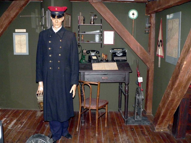 Stary kolejarski mundur i biuro naczelnika stacji na wystawie w muzeum.