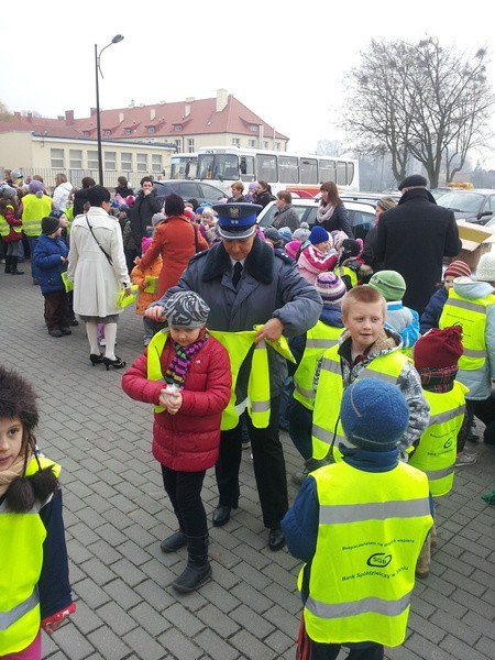 Dzieci otrzymały kamizelki odblaskowe. Agnieszka Sobieralska pomogła im je założyć