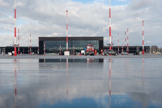 Bez opóźnień trwa budowa Portu Lotniczego Warszawa – Radom. Dużo się dzieje na terenie lotniska oraz w budynkach lotniskowych. Na zdjęciu powyżej zwraca uwagę asfalt położony już na płycie postojowej dla ciężkich samolotów kodu E, czyli na  przykład typu Boeing 787-9 i 777-9X (to wersje popularnego dreamlinera). Wewnątrz terminala i innych budynków lotniskowych trwają prace wykończeniowe. Na kolejnych slajdach zobacz najnowsze zdjęcia z budowanego lotniska >>> 