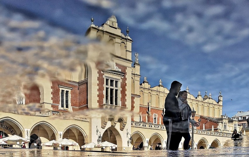 Kraków. Rynek Główny odbity w kałuży. Niecodzienna perspektywa [ZDJĘCIA]