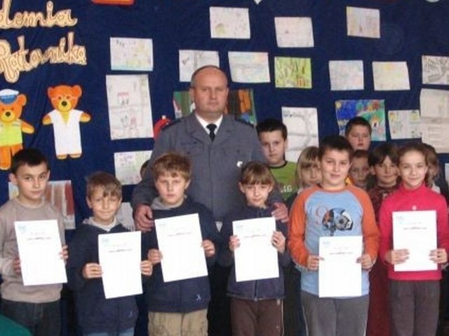 Uczniowie nagrodzeni w konkursie o bezpieczeństwie na drodze pozowali do zdjęcia ze Zdzisławem Owczarskim z białobrzeskiej policji.