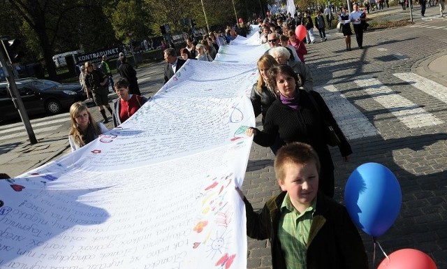 Uczestnicy marszu przygotowali długą wstęgę, flagi i balony.