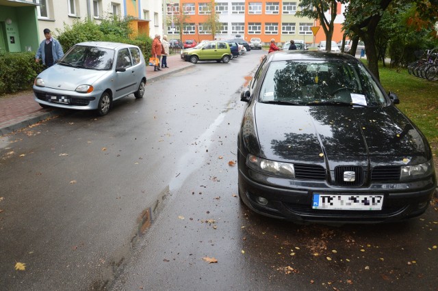 Osiedlowa uliczka między blokamprzy ulicy Okulickiego 28 i 30, z prawej auto z mandatem, z lewej bez mandatu