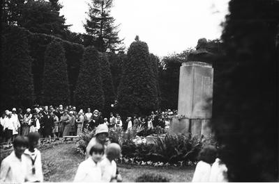 Grupa dzieci i dorosłych pod pomnikiem Henryka Jordana.