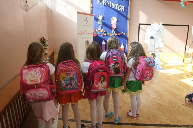 Szkoła podstawowa, uczniowie z plecakami, zdjęcie ilustracyjne.