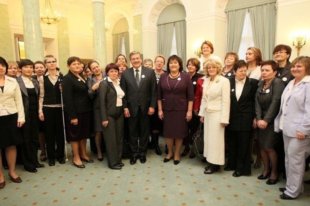 Elżbieta Wysocka, w  bialej garsonce, stoi obok pary prezydenckiej.