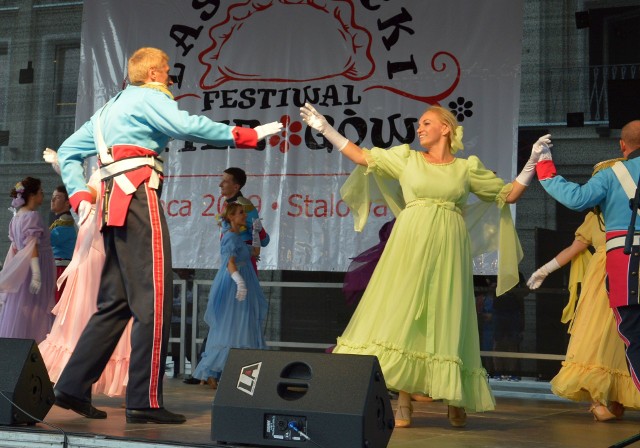 Elżbieta Żurawska w zielonkawej sukni tańczy poloneza na scenie na II Lasowiackim Festiwalu Pierogów w Stalowej Woli