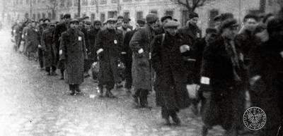 Maszerujący Żydzi z krakowskiego getta. Zdjęcie zrobione prawdopodobnie podczas któregoś z wysiedleń. FOT. ARCHIWUM IPN