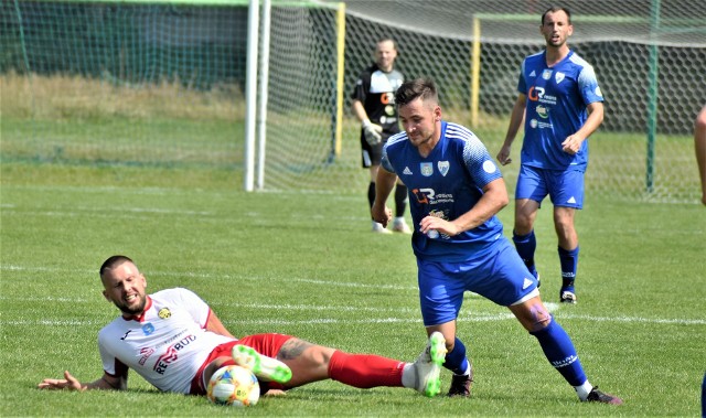 Keeza IV liga piłkarska w Małopolsce. MKS Trzebinia - Unia Oświęcim 0:3. Na zdjęciu: Michał Szewczyk (w niebieskim stroju), autor trzech goli dla oświęcimian, mija Adriana Zybińskiego (MKS Trzebinia)