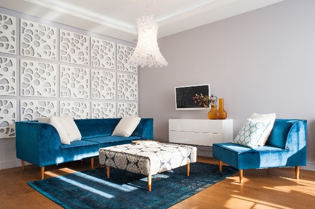 Turkusowe meble i dywan świetnie wyglądają wśród białych ścian.