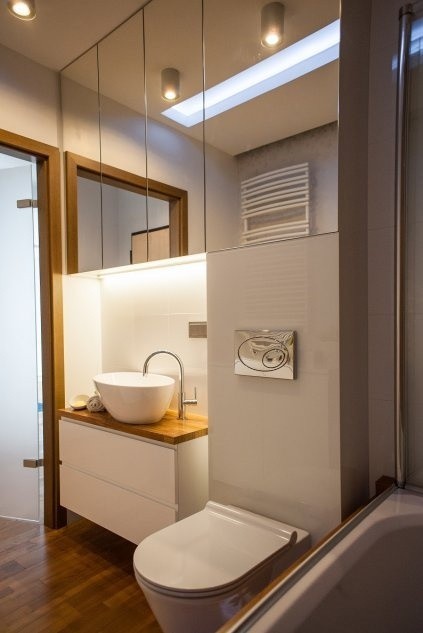 Biała aranżacja łazienki z drewnianym blatem.