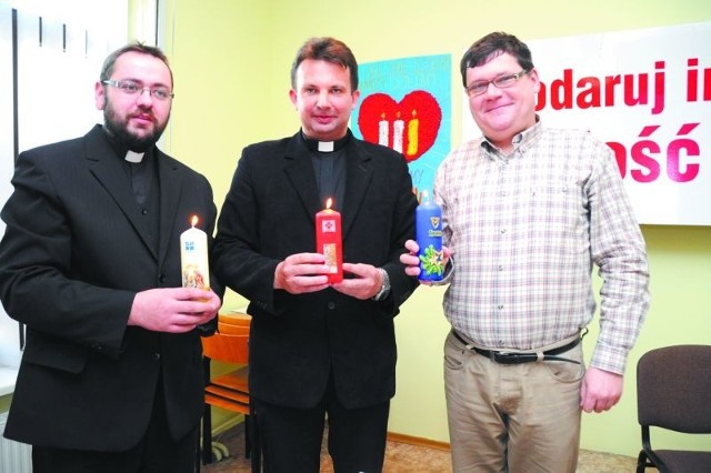 Ksiądz Tomasz Wigłasz z parafii ewangelicko-augsburskiej ( z lewej), ksiądz Grzegorz Kłoczko, dyrektor białostockiej Caritas ( w środku) oraz Marek Masalski zachęcają do kupowania świec